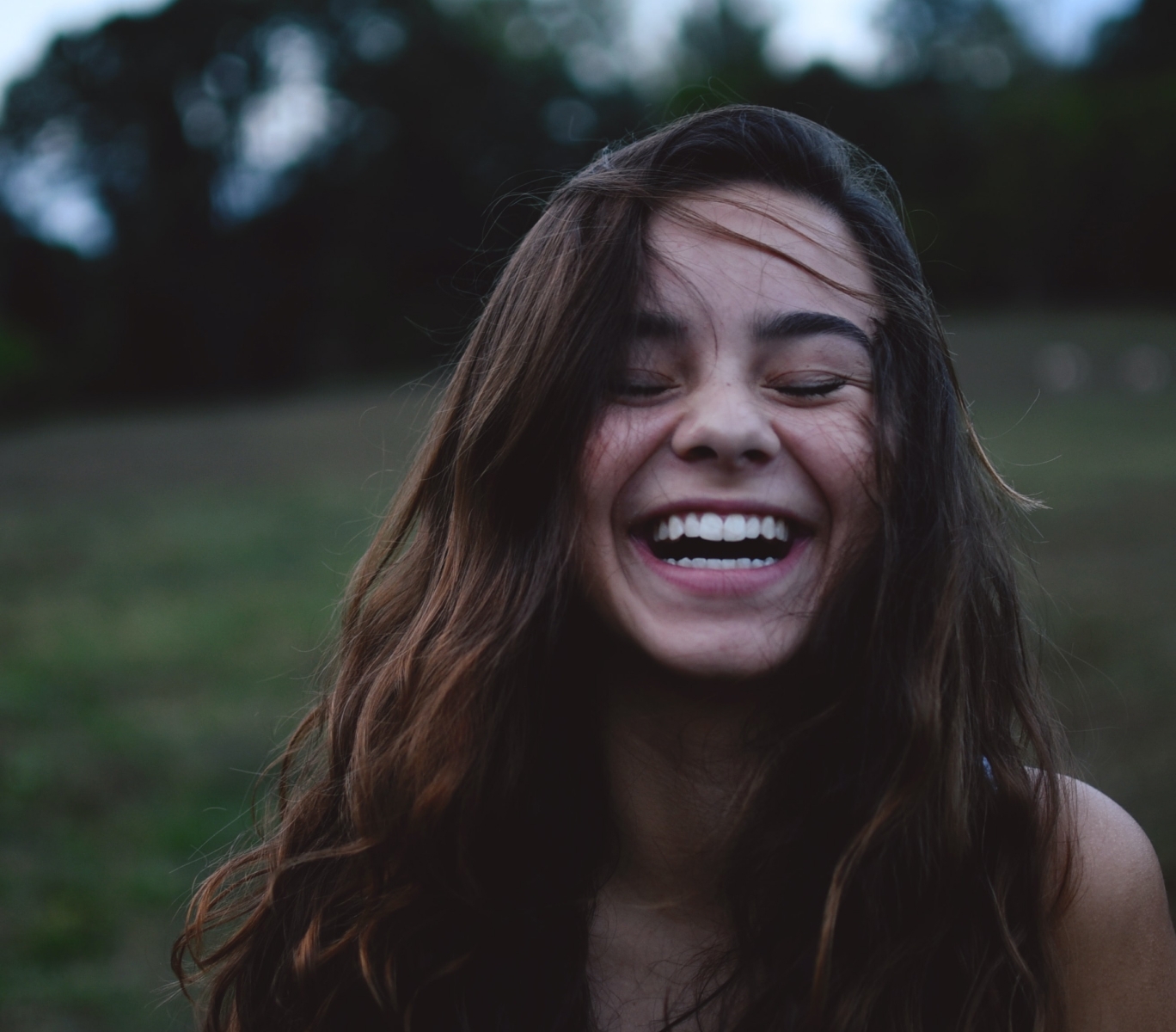 A women laughing at dusk