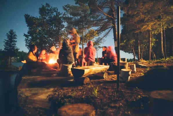 An image of friends enjoying the warmth of a campfire