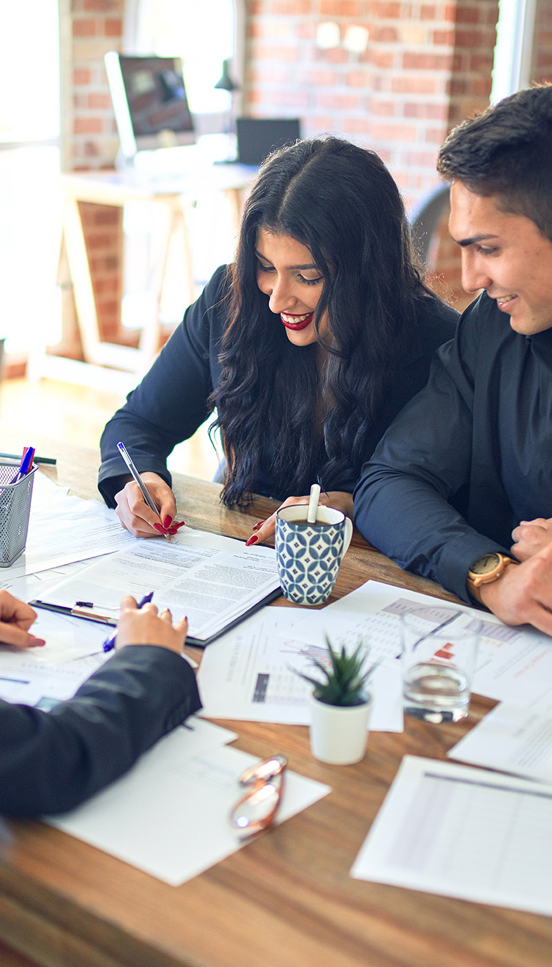 Couple signing mortgage papers at a desk